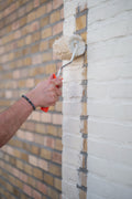Het aanbrengen van primer muur buiten
